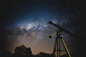 Telescope and stars in night sky 